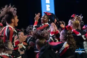 Responsables d’équipe de cheerleading (cheer québec) applaudissant des athlètes sur scène pendant une compétition