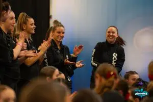 Entraîneurs de cheerleading (cheer québec) motivant et applaudissant leurs équipes lors d'un entraînement ou d’un événement.